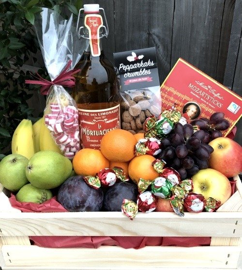 Presentkorg i trälåda med frukt, choklad och delikatesser